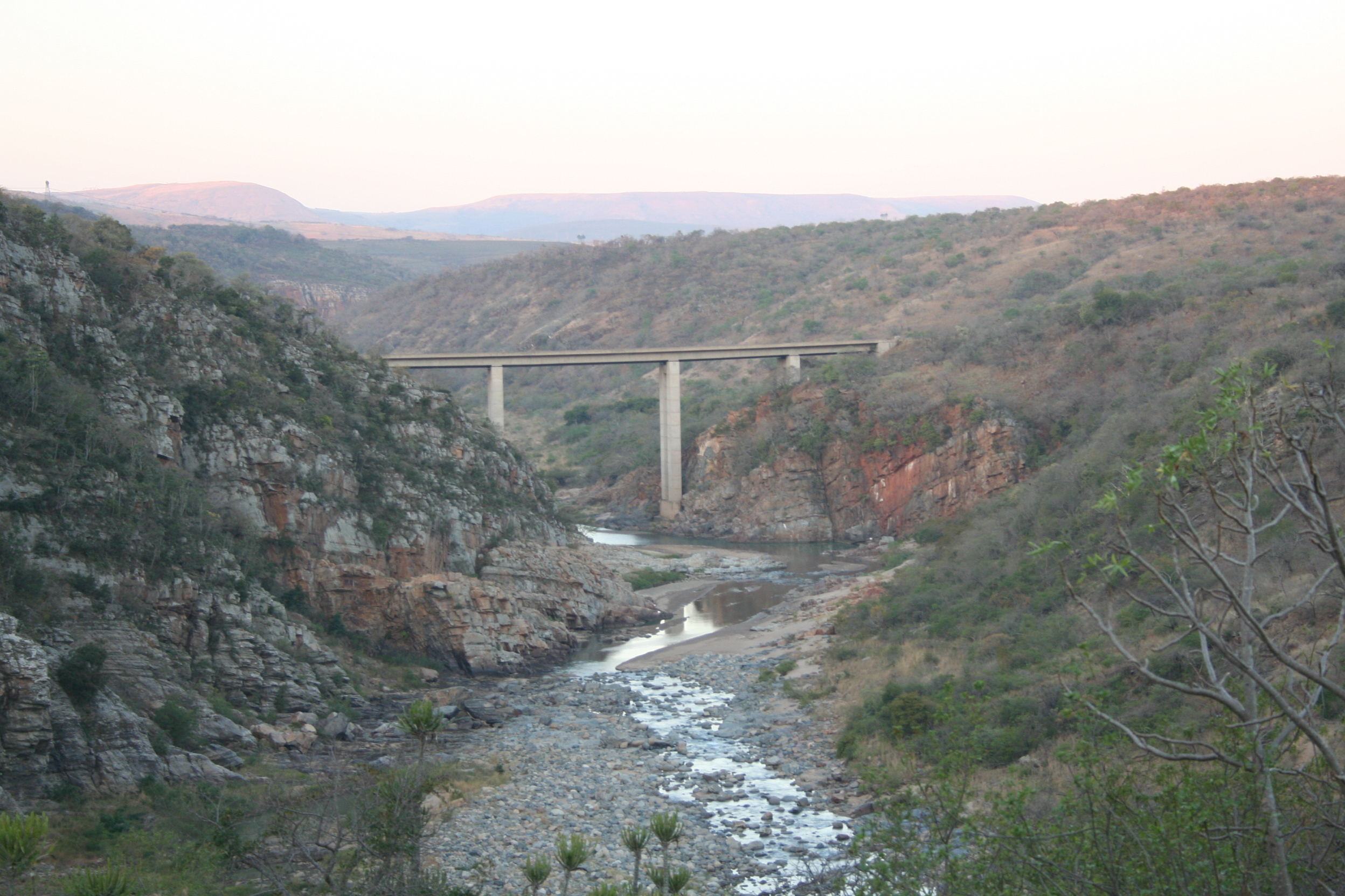 Dry grass valley with a bridge and small river